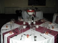 Tall cone vase with large ball candle and roses as centrepiece on wedding guest table